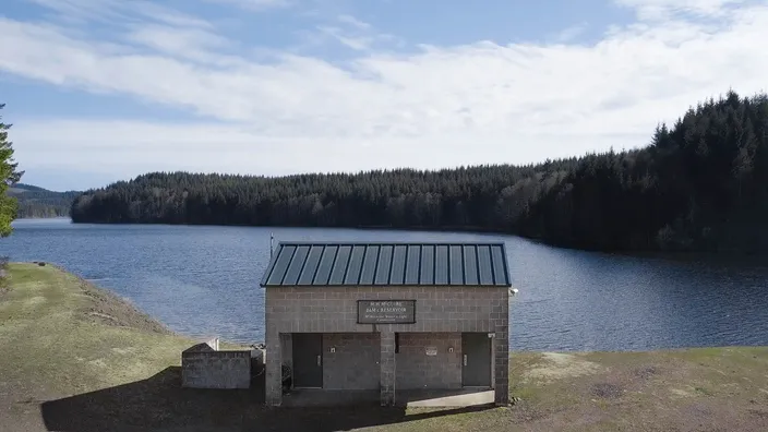 McGuire Dam reservoir and the water-site control building beside the shoreline.