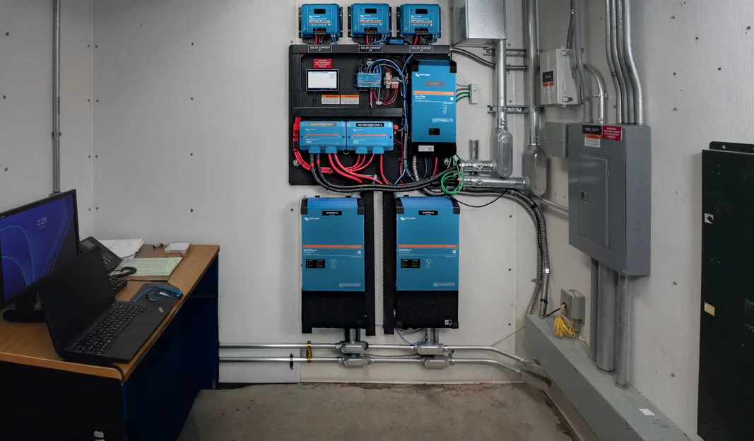 Installed Victron power equipment at the water site, with three solar charge controllers and separate inverter units.