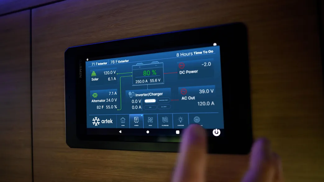 Garmin display mounted in a vehicle interior, showing an Artek power-system overview.